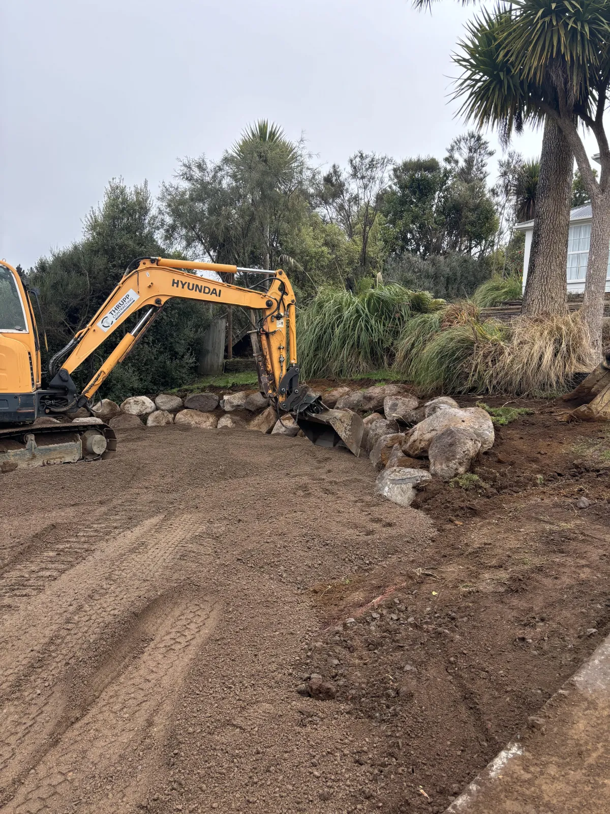 Retaining wall construction underway with excavation work.