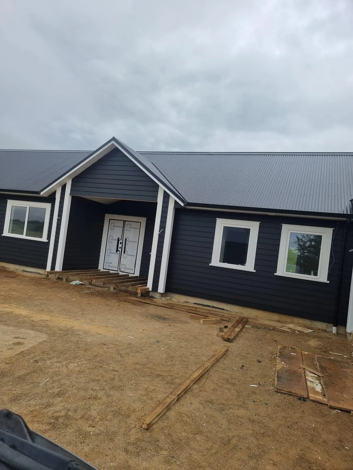 New build in progress with black-painted exterior and white window trims in Waikato