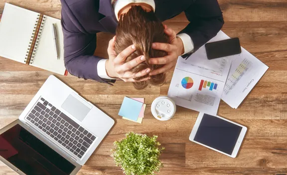 Frustrated hiring manager reviewing resumes, symbolizing common recruiting mistakes that lead to lost top talent