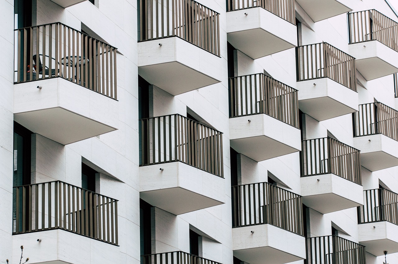 The image shows a modern apartment complex with a central courtyard, green spaces, and playgrounds, reflecting the appeal of urban living. The view from a balcony highlights the shared, community-oriented atmosphere common in rental properties. The headline, "Homeownership Decline Among Millennials: Why Financial Challenges and Lifestyle Choices Favor Renting," points to a growing trend among millennials who opt to rent rather than buy homes. The image and title together suggest that rising property prices, student debt, and a desire for flexibility are influencing this generation's preference for renting over the long-term commitment of homeownership.