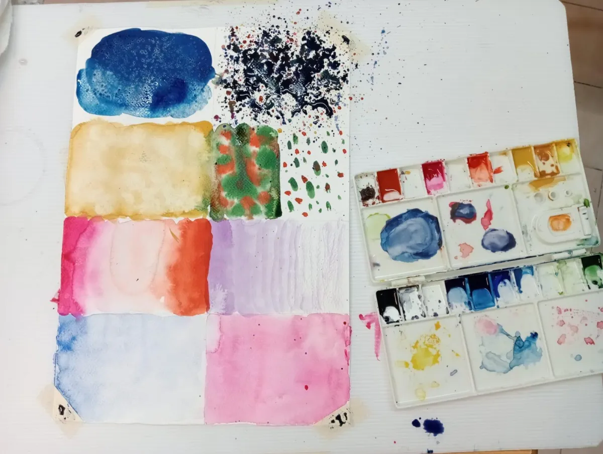 Niños mostrando ejercicios de acuarela en clase artística en CANICARTE