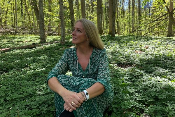 Dame sitter og reflekterer i skogen