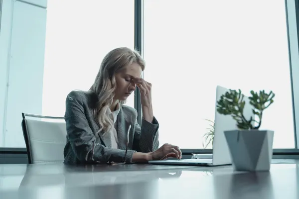 Woman thinking hard while working on her laptop