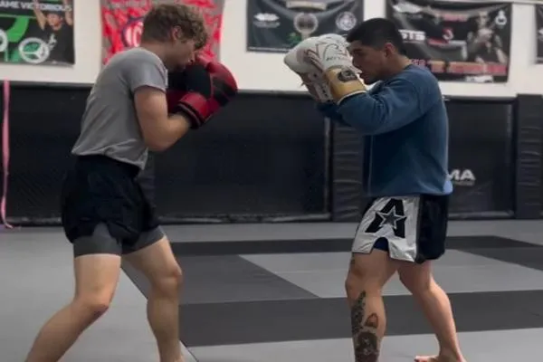 Fighter training in MMA with focus on striking and grappling techniques.