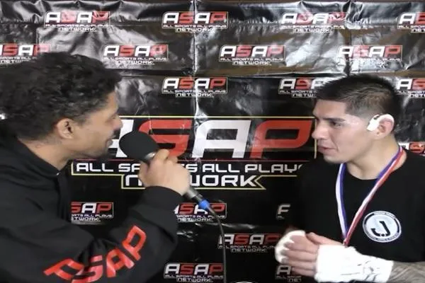 Fighter being interviewed by the Apex Fight League media team, in partnership with ASAP Sports Network, after a victory, with a microphone capturing the moment.