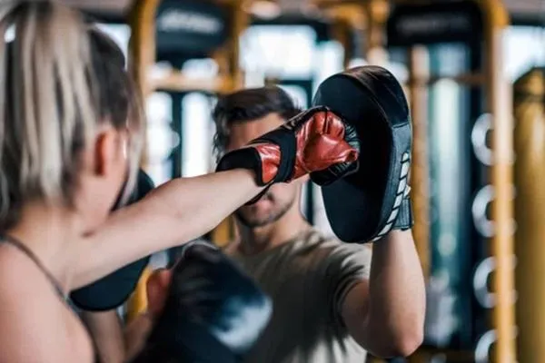 Close-up of a fighter practicing padwork with their coach, focusing on precision and technique in preparation for fight day.
