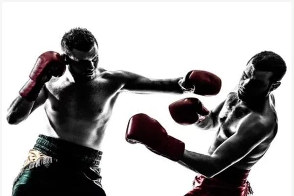 Two fighters in action, one executing a feint while the other reacts, demonstrating deception and timing in striking combat.