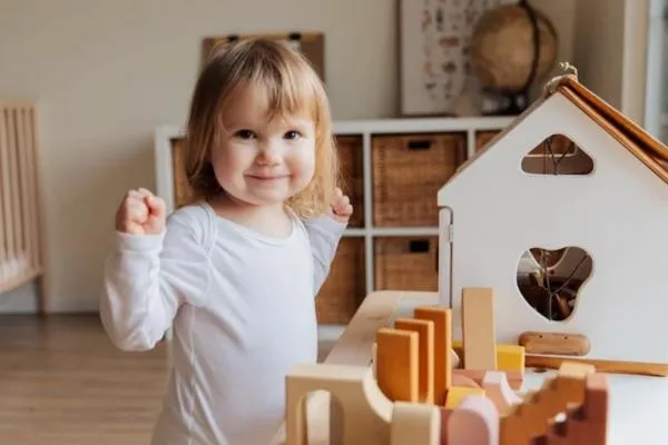 a little girl playing with her toy house