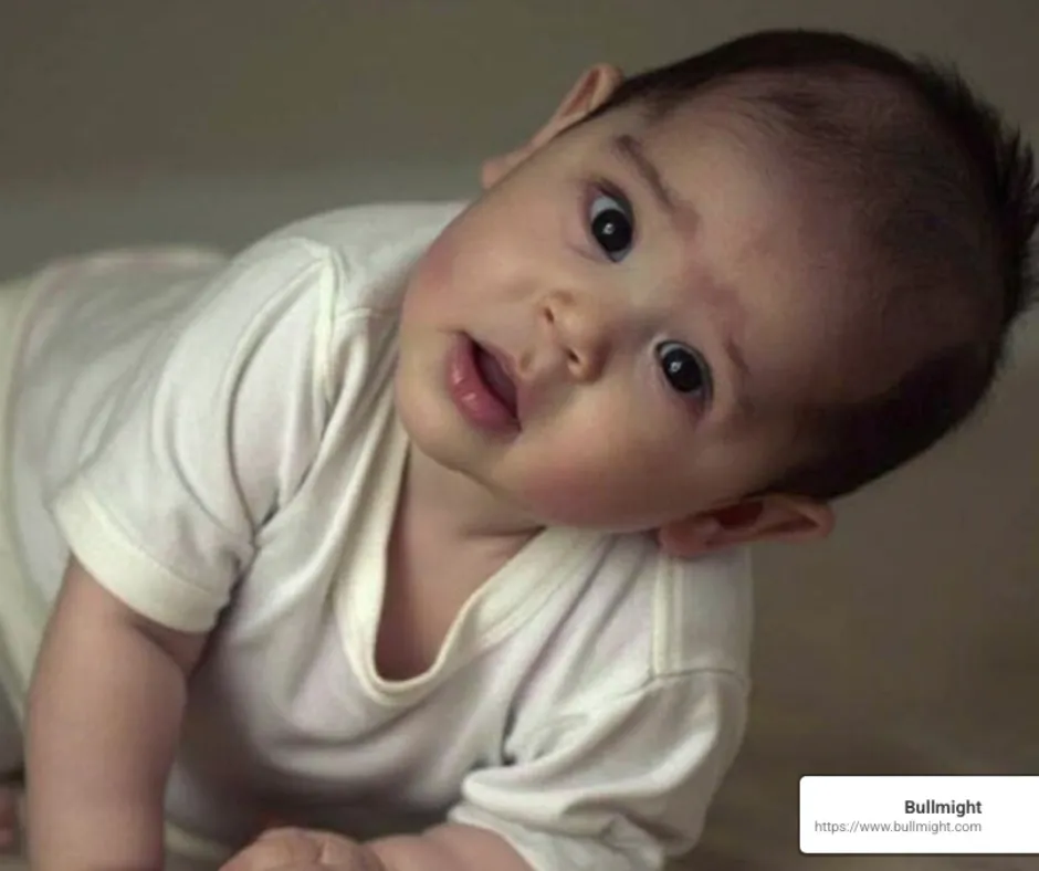 Baby lying on stomach with curious expression, emphasizing vulnerability, relevant to Shaken Baby Syndrome awareness and prevention.