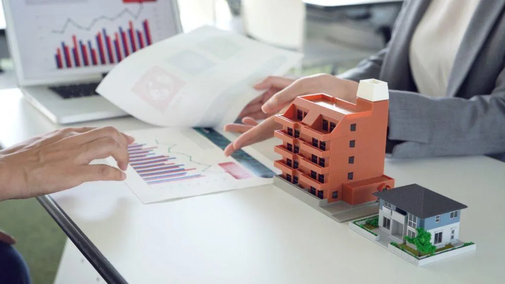 showing reports next to model multifamily property and single family property