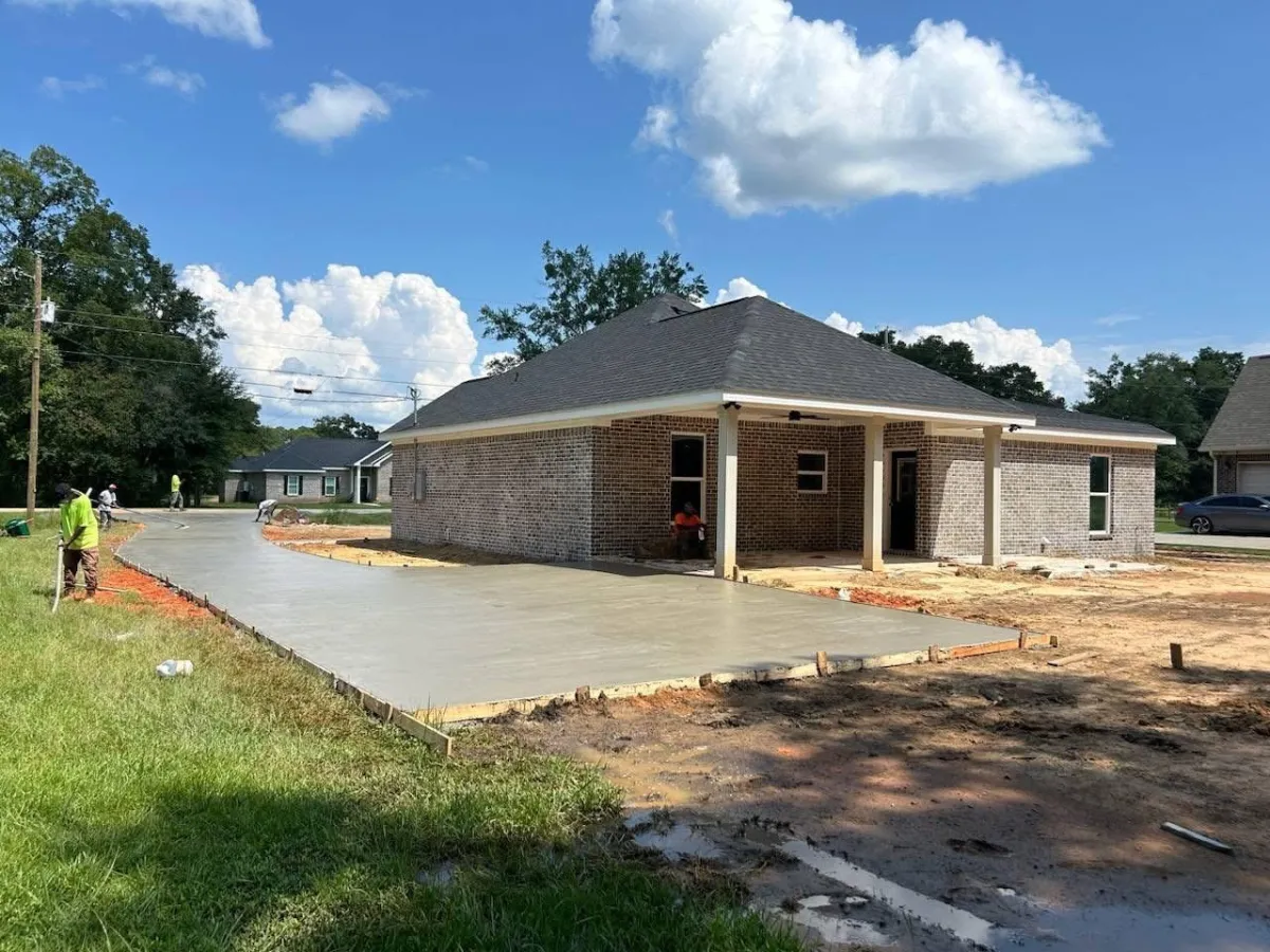 Exterior new build home with new concrete walkway and car port