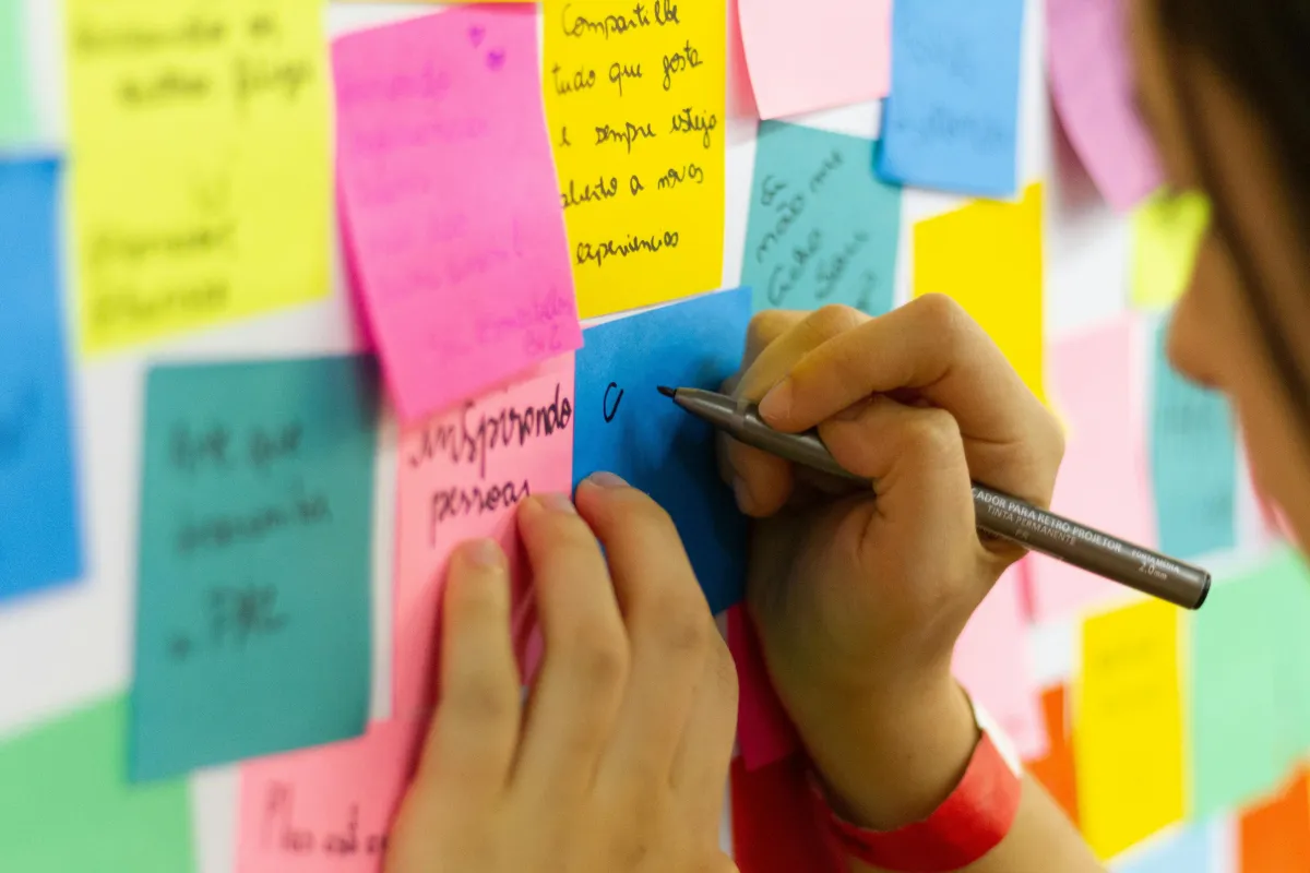 A person adding ideas on a sticky note: photo by Bruno Beuno from Pexel