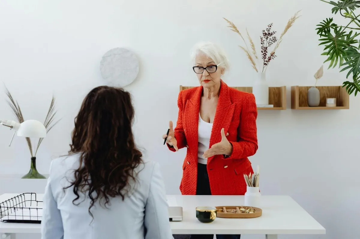Professional job interview scene with interviewer and candidate demonstrating positive body language and eye contact in modern office setting