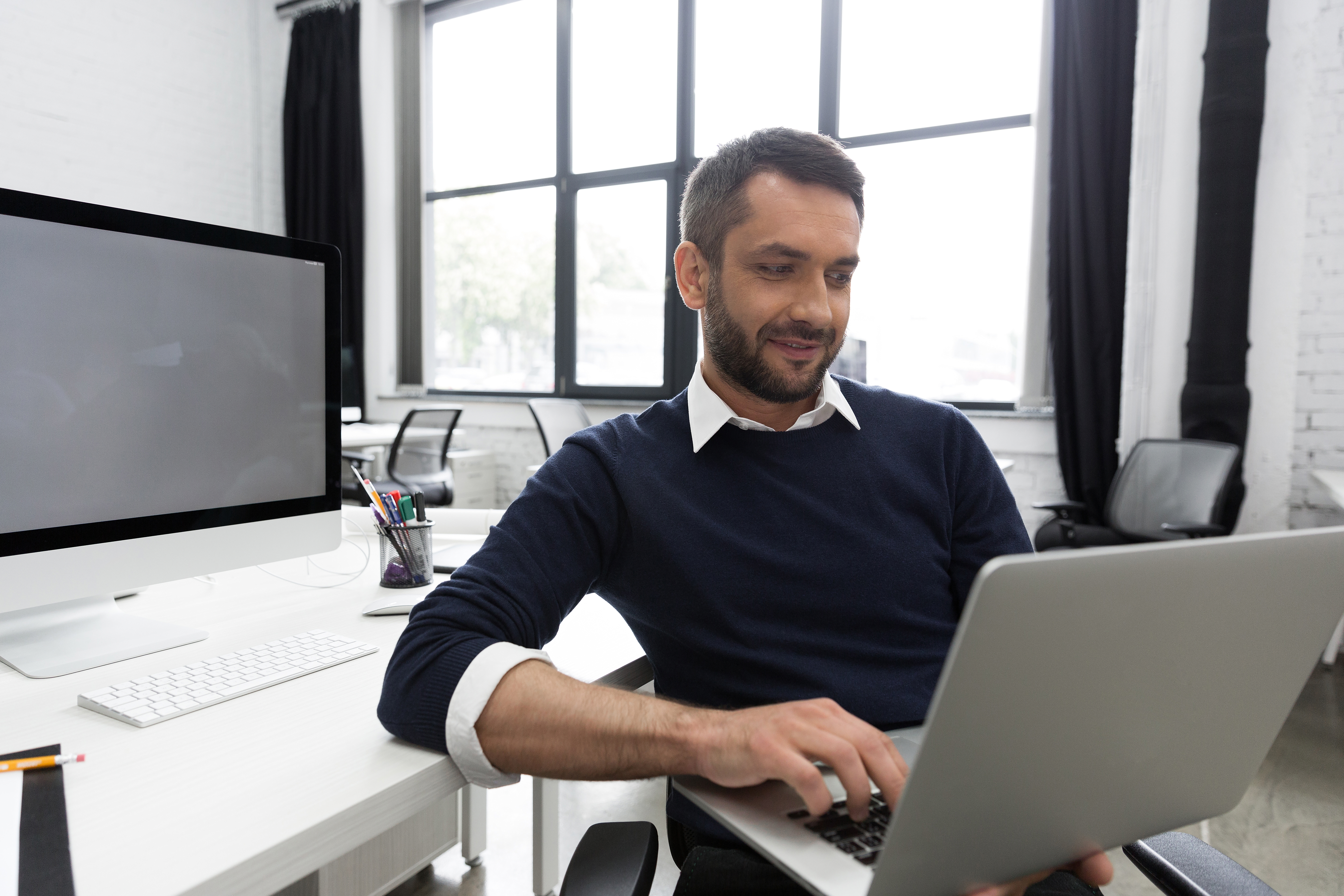 A business owner working on a laptop in an office.