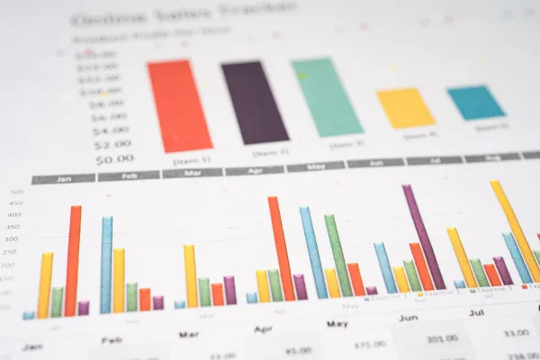 Image of an investor reviewing a business plan or financial data, with a background of Asian market trends or growth charts.