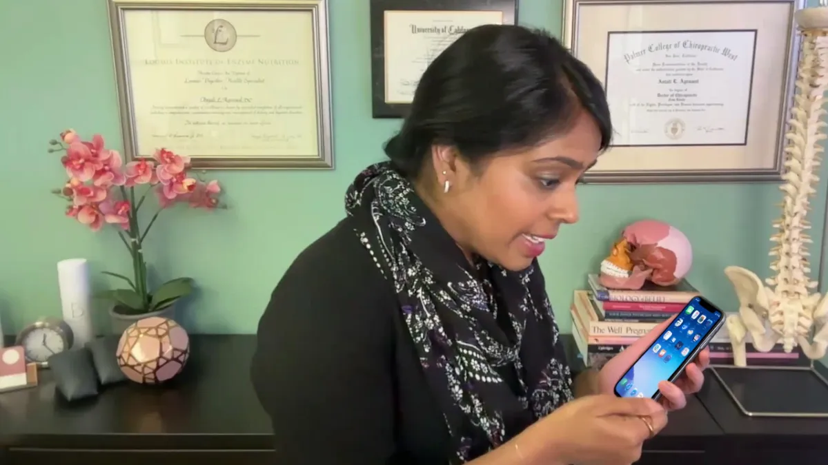 dr. anjali looking down at her cell phone simulating micro trauma