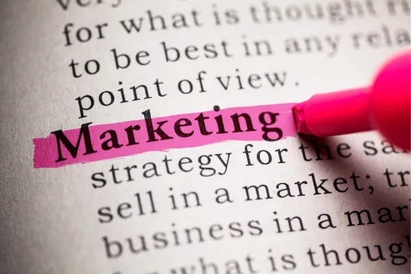 Picture of highlighting the word marketing in a textbook