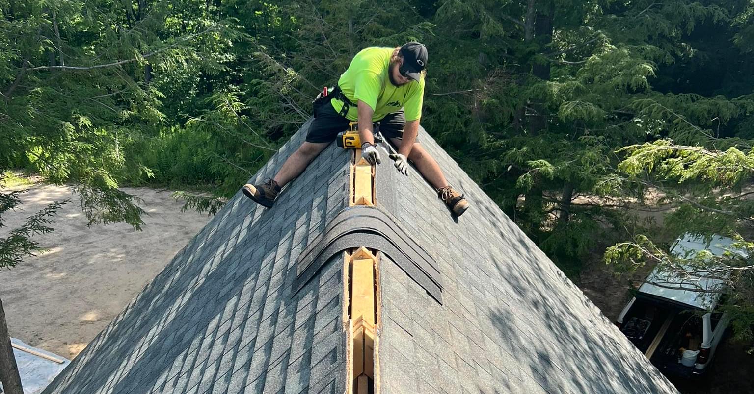 K&M Roofing owner Tyler patching the top of a pitched roof