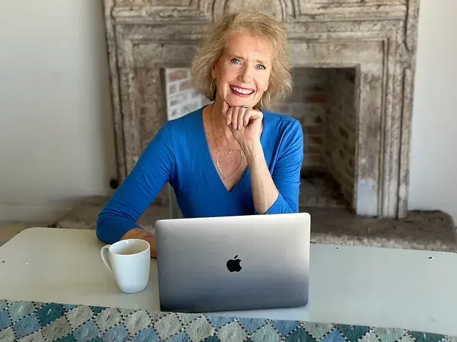 Lynn Kirkham working on a laptop, focused on public speaking.