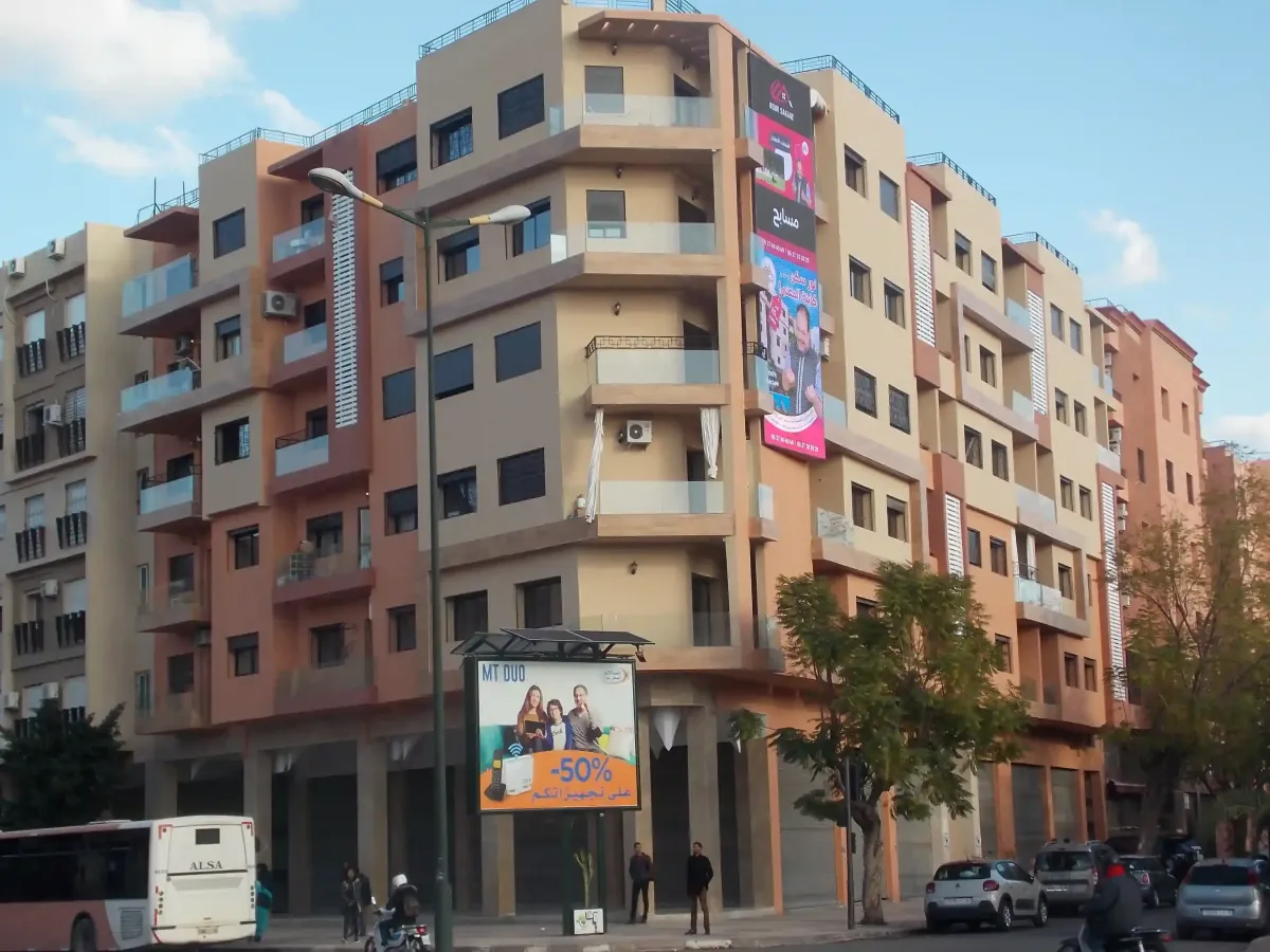 Immeuble mixte Marrakech : menuiserie aluminium noire et balcons en acier sur façade blanche
