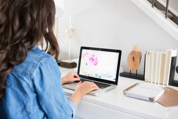 Creating a digital product with Canva on a laptop – cozy home workspace setup for solopreneurs
