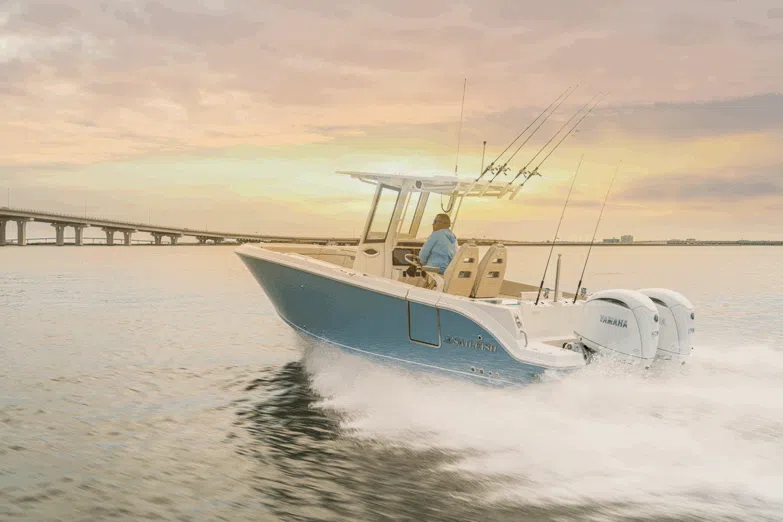 A Sailfish boat glides to a bridge in sunset
