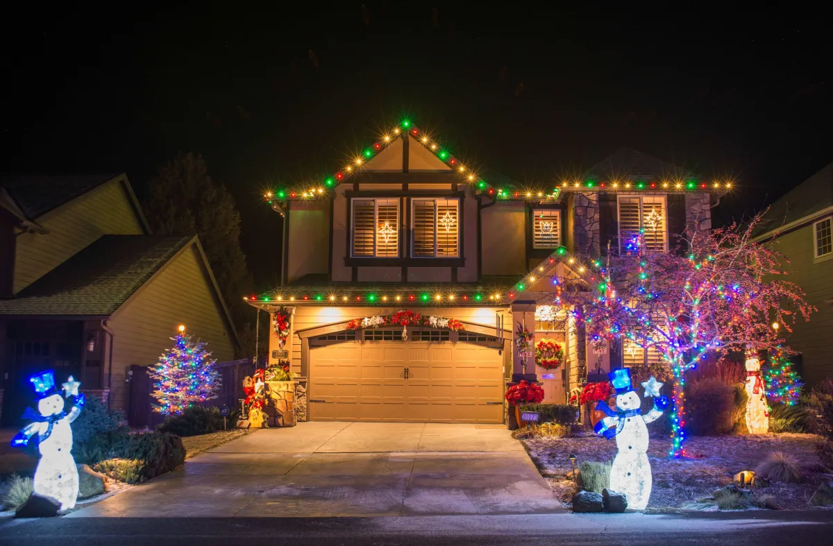 Colorful Christmas light display on a decorated house with festive holiday decorations and themes