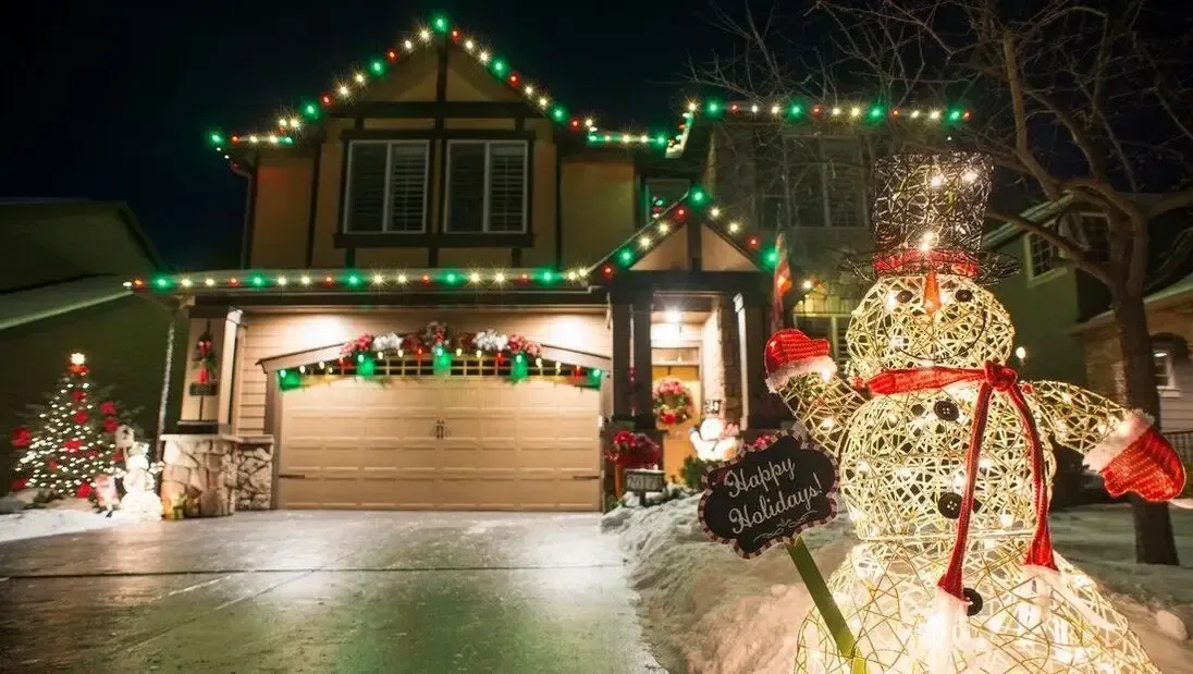 Christmas lights illuminating a snowy yard and house, creating a magical and enchanting winter scene.