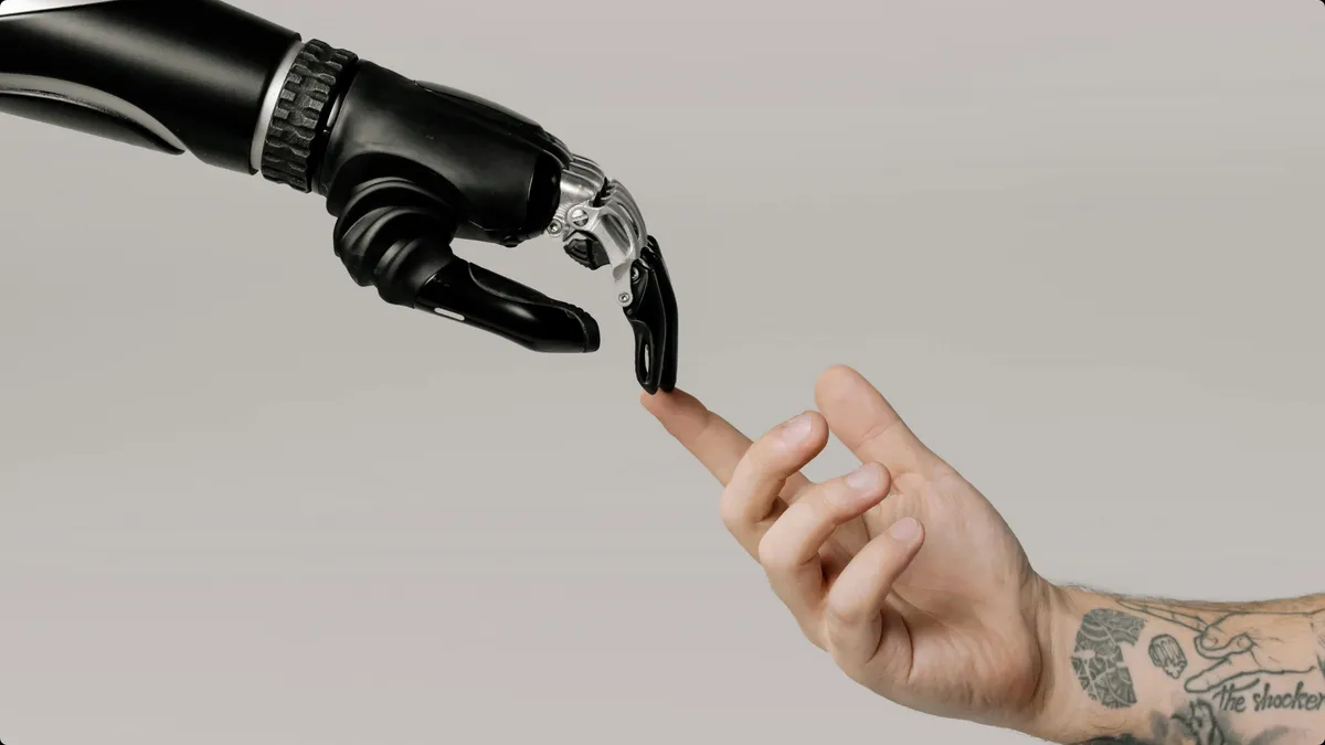 Robotic hand symbolizing AI automation and human hand touching showing they are joined together in marketing for modern businesses