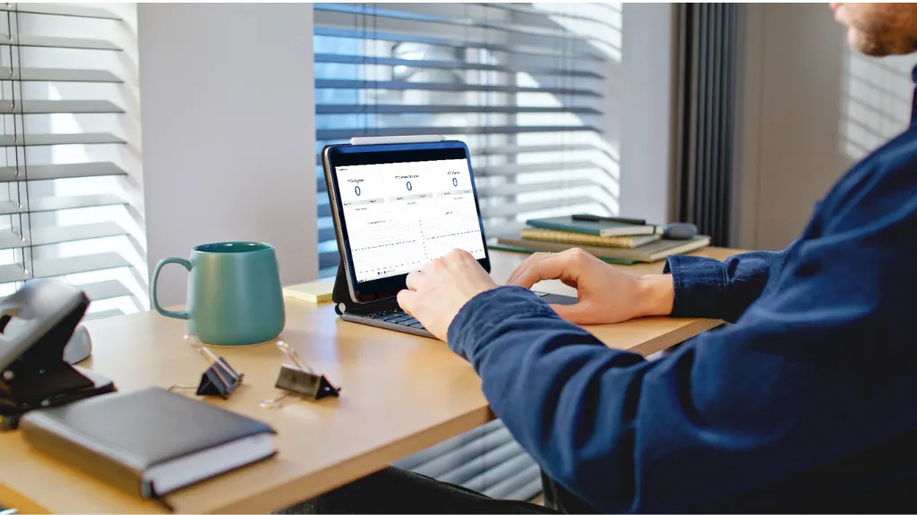 Real estate agent reviewing listing pipeline in a branded business journal at modern desk.