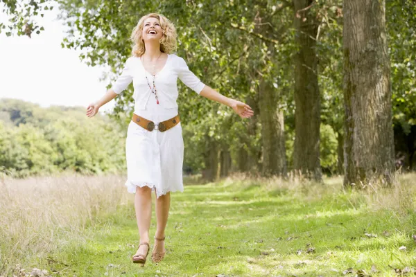 a smiling woman is wearing a white dress 