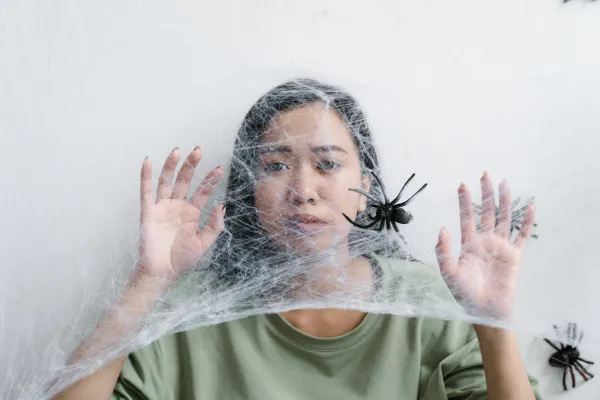 the women looks scared of the spider's web