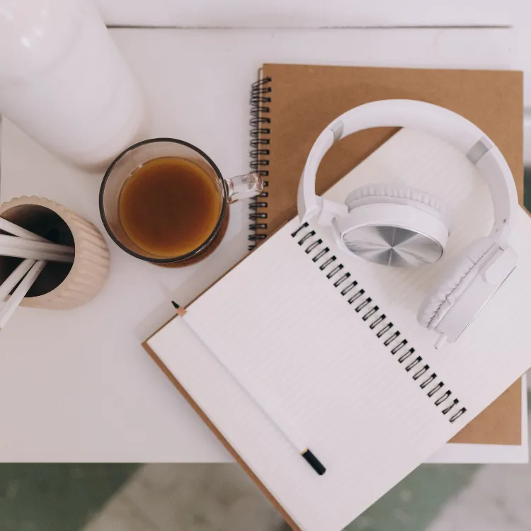 Headphones beside a warm cup of coffee, symbolizing gentle grief support through hypnotherapy-inspired audio