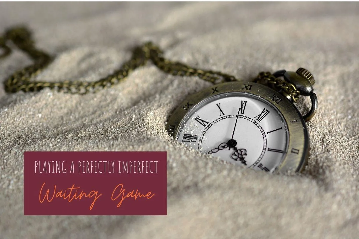 An old-style pocket watch half buried in sand