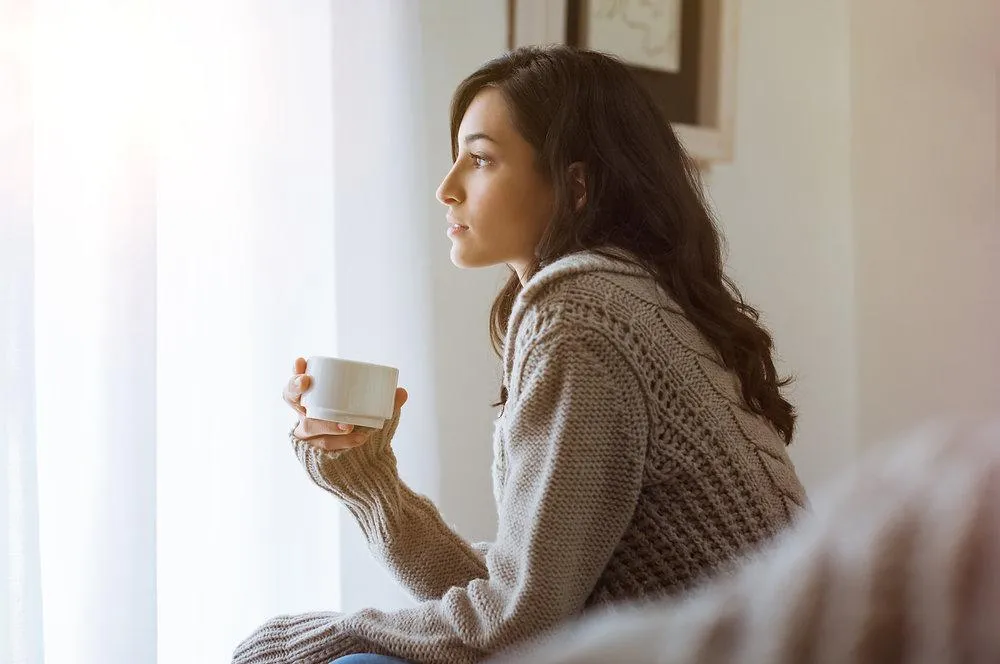 A reflective woman journaling at home during the pandemic, symbolizing personal growth. Get Christian counseling in 60637 today.