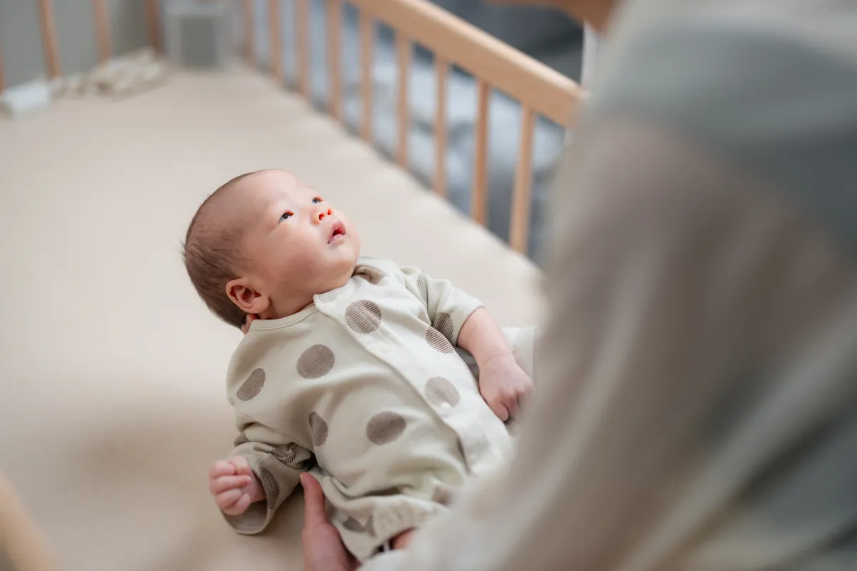 laying baby down in cot