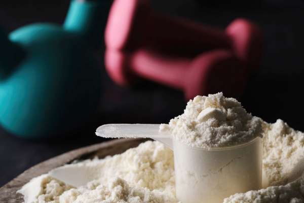 Measuring scoop containing white creatine powder used as a dietary supplement.
