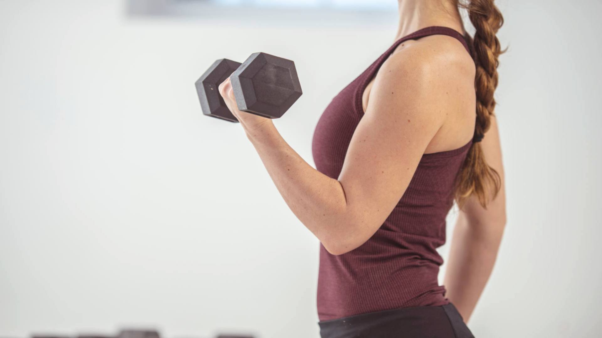 Woman lifting a dumbbell during a workout.