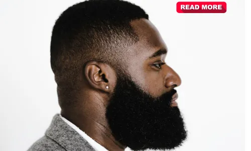 A bottle of rosemary oil next to a thick, well-groomed beard – the secret to natural beard growth!