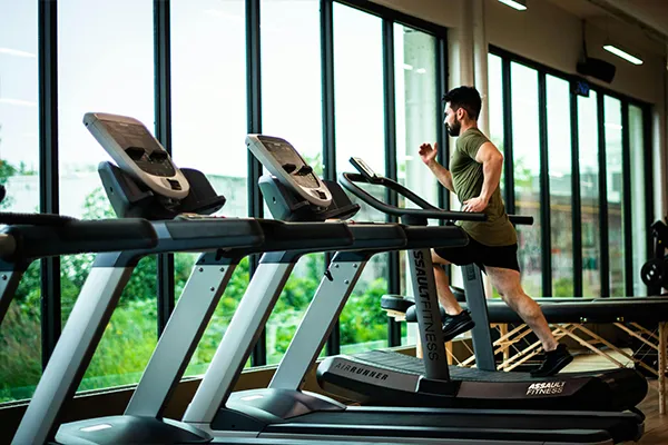 Man running on a treadmill, focusing on fitness as a part of a healthy, sober lifestyle.