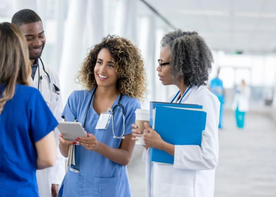 2 Female 1 Male Doctor sharing notes on a notepad