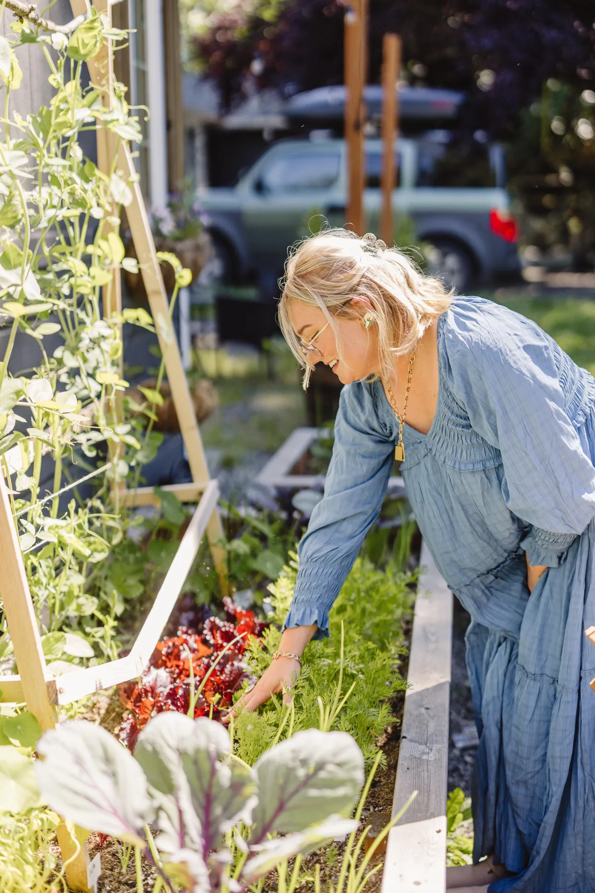 brooklyn beckdol reaching into the kitchen garden to pick a weed