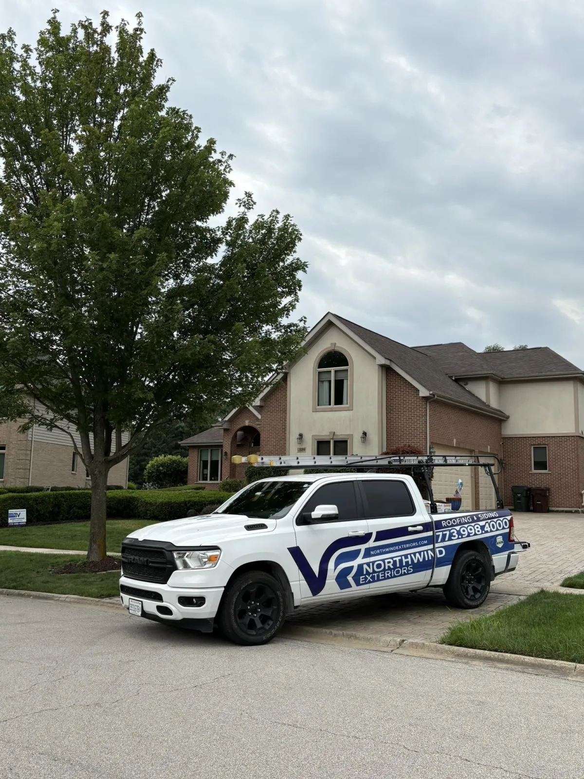 Completed residential roof and siding project by Northwind Exteriors, with a branded company truck in the driveway.