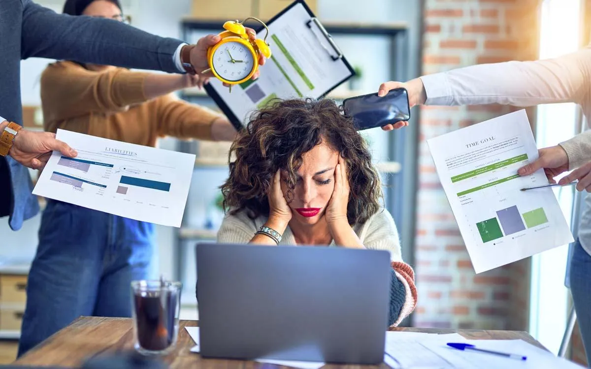 photo of a woman frustrated because so many people are handing her so many tasks and she is trying to focus