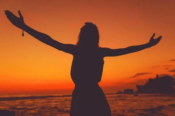 woman with arms outstretched experessing peace and fulfillment.