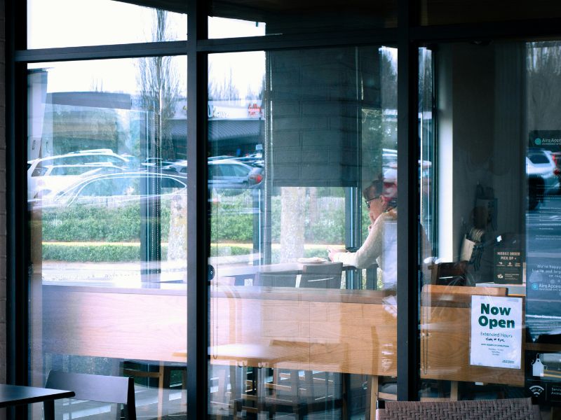 an image of a woman inside a cafe by the window