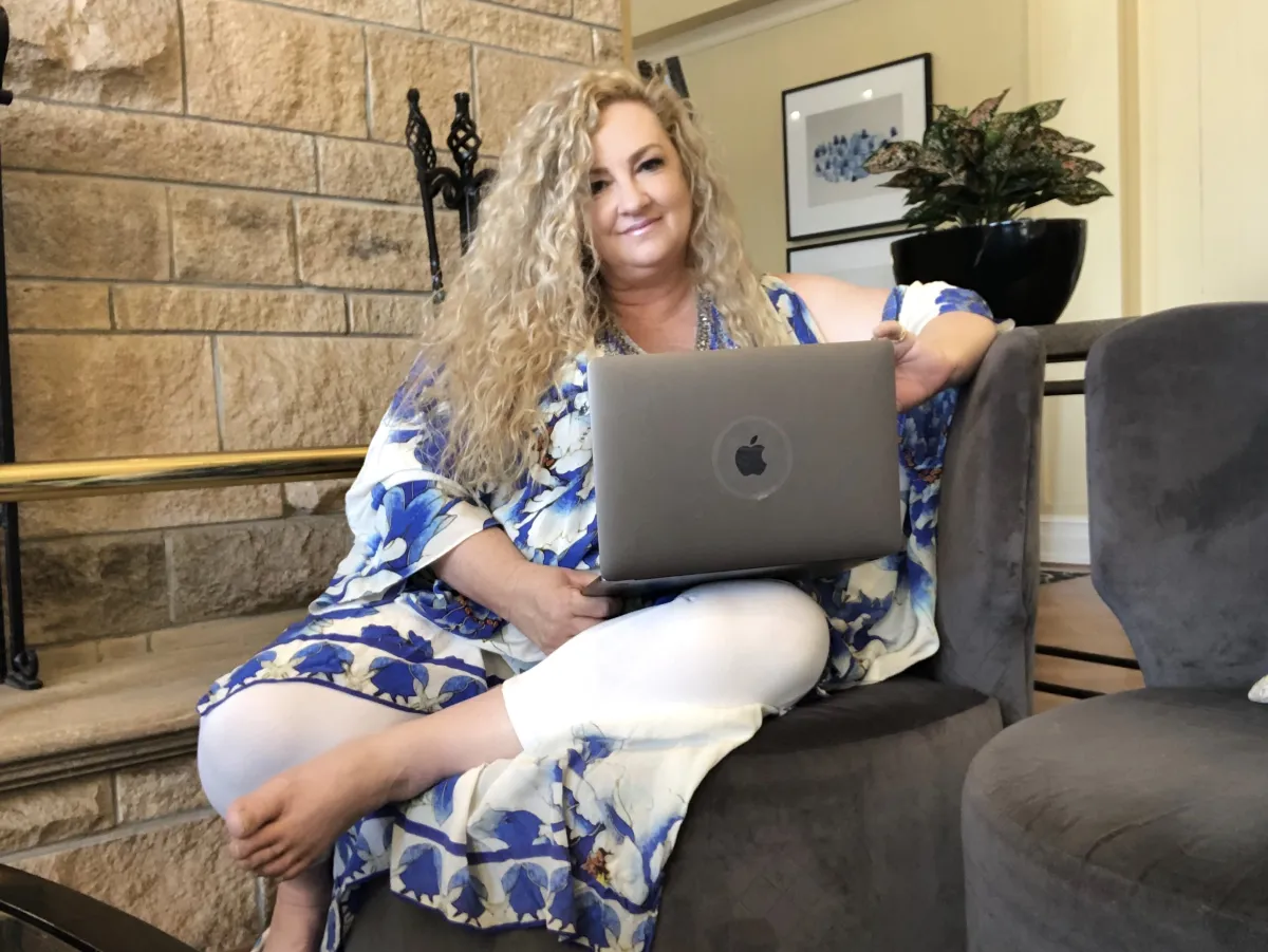 Debbie Mewes with a laptop doing Zoom readings
