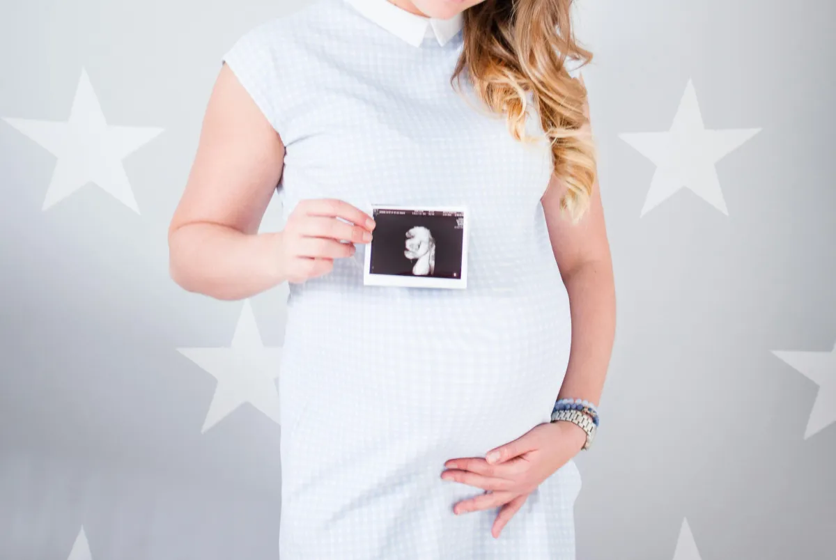 Pregnant woman holding an ultrasound photo