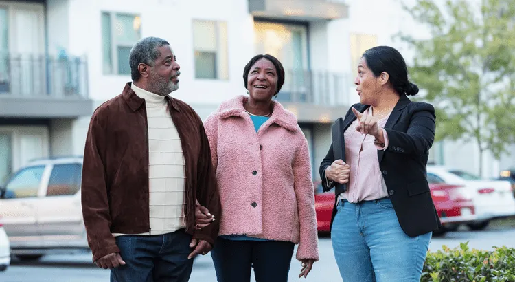 2 women and a man having a conversation on the street during daytime