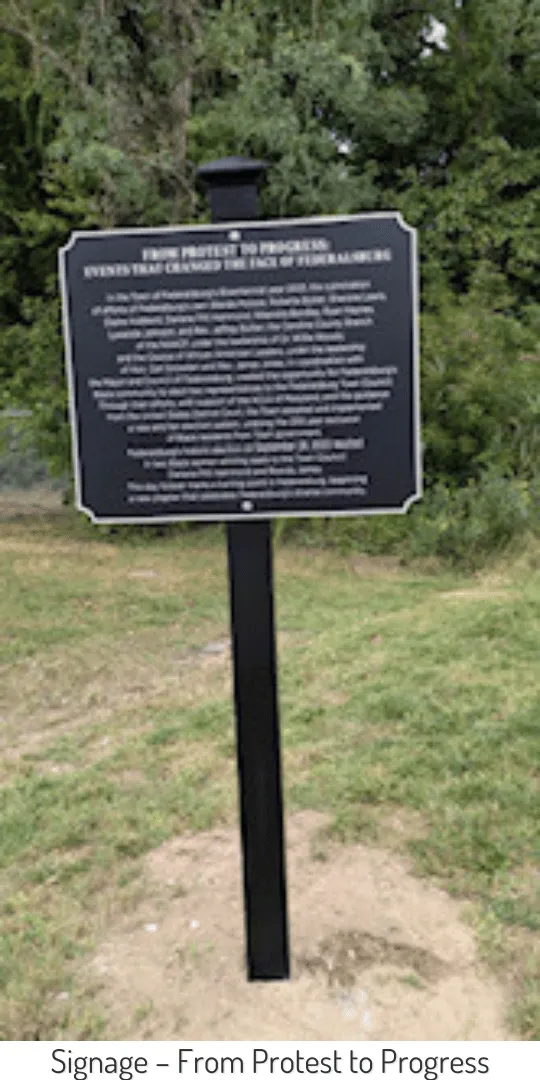 Photo of the new From Protest to Progress Historic Marker in Federalsburg after its unveiling. It is black with white text.